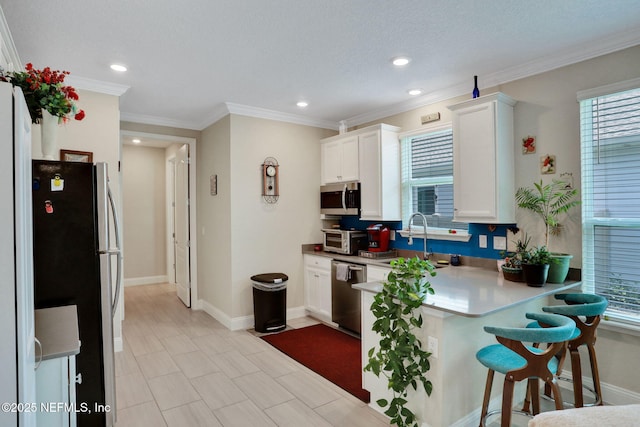 363 Latrobe Ave, Saint Augustine, FL 32095 - kitchen with appliances with stainless steel finishes, white cabinetry, a peninsula, a breakfast bar, and recessed lighting