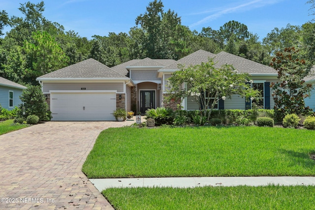 363 Latrobe Ave, Saint Augustine, FL 32095 - view of front of home with a garage, driveway, a front lawn, a shingled roof, and stone siding