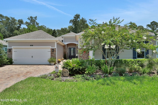 363 Latrobe Ave, Saint Augustine, FL 32095 - view of front facade with an attached garage, decorative driveway, stone siding, and roof with shingles