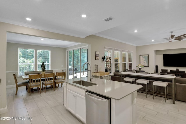 363 Latrobe Ave, Saint Augustine, FL 32095 - kitchen with open floor plan, dishwasher, ornamental molding, a kitchen island with sink, and white cabinetry