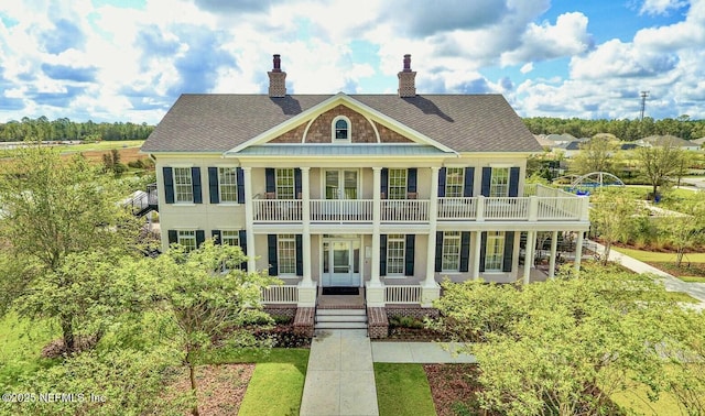 363 Latrobe Ave, Saint Augustine, FL 32095 - view of front of property with covered porch, a chimney, a shingled roof, and a balcony