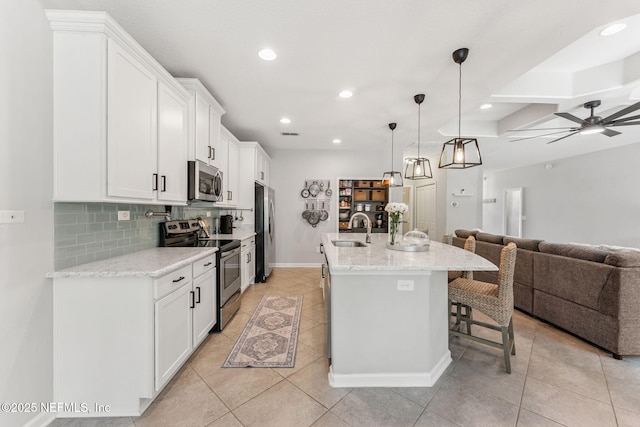 47 Mercutio Ln, Saint Augustine, FL 32092 - kitchen with open floor plan, stainless steel appliances, a breakfast bar area, white cabinets, and recessed lighting