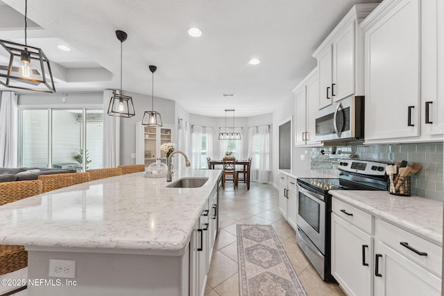 47 Mercutio Ln, Saint Augustine, FL 32092 - kitchen featuring appliances with stainless steel finishes, tasteful backsplash, white cabinets, an island with sink, and recessed lighting