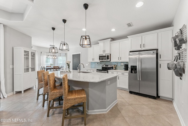 47 Mercutio Ln, Saint Augustine, FL 32092 - kitchen with stainless steel appliances, tasteful backsplash, white cabinets, light tile patterned floors, and recessed lighting