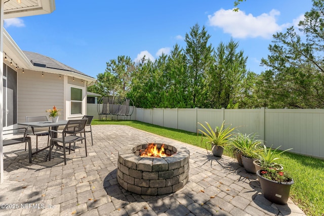47 Mercutio Ln, Saint Augustine, FL 32092 - fenced backyard featuring a trampoline, a patio area, a fire pit, and outdoor dining space