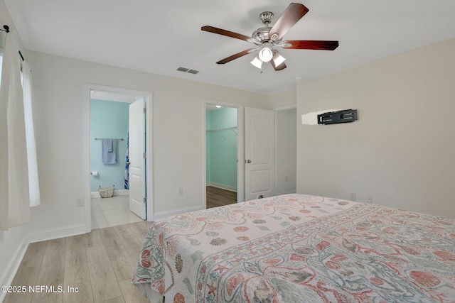35 Root Ln, Saint Augustine, FL 32084 - bedroom with light wood finished floors, a walk in closet, a ceiling fan, and connected bathroom