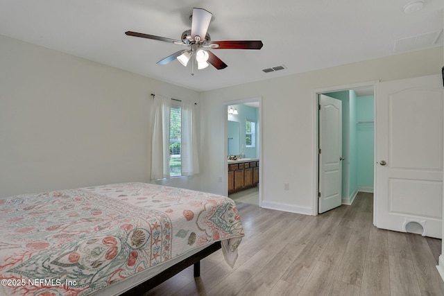 35 Root Ln, Saint Augustine, FL 32084 - bedroom featuring light wood finished floors, a spacious closet, a ceiling fan, and ensuite bath