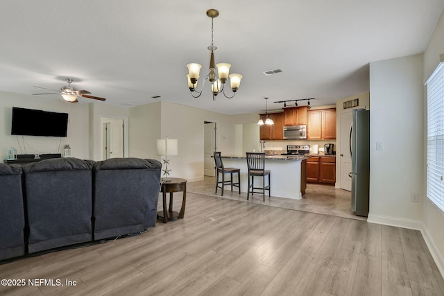 35 Root Ln, Saint Augustine, FL 32084 - living area featuring a chandelier, light wood-type flooring, ceiling fan, and rail lighting