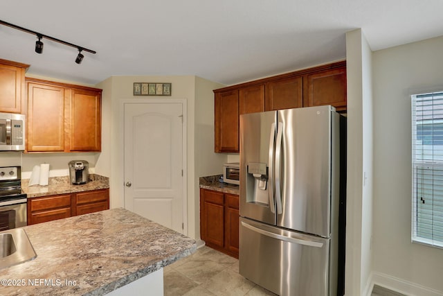 35 Root Ln, Saint Augustine, FL 32084 - kitchen with appliances with stainless steel finishes, rail lighting, and brown cabinets