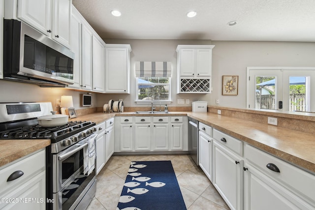 1083 Three Forks Ct, Saint Augustine, FL 32092 - kitchen featuring appliances with stainless steel finishes, white cabinetry, recessed lighting, light tile patterned flooring, and light countertops
