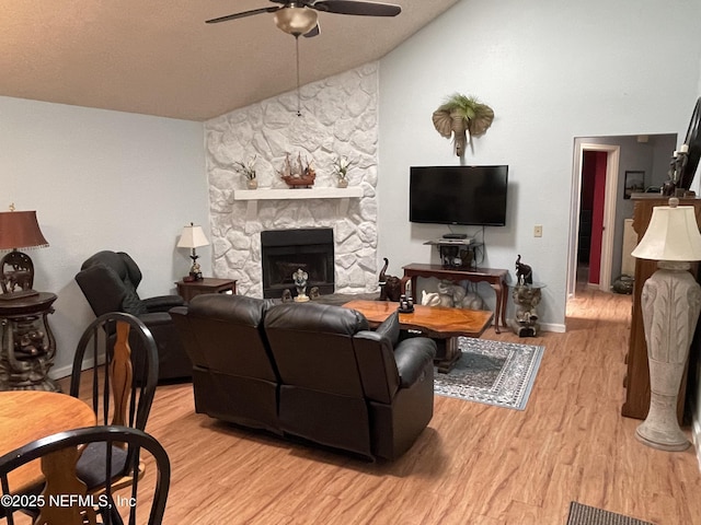 1855 N Alberta Ct, Middleburg, FL 32068 - living area with a ceiling fan, lofted ceiling, a stone fireplace, and light wood-type flooring