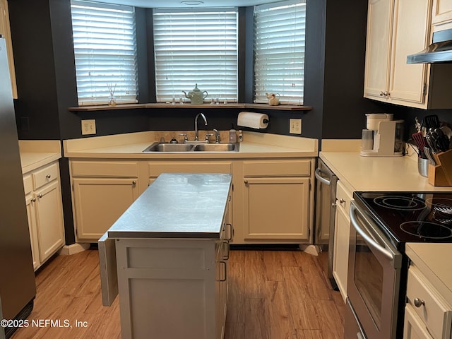 1855 N Alberta Ct, Middleburg, FL 32068 - kitchen with appliances with stainless steel finishes, light wood-type flooring, light countertops, under cabinet range hood, and a kitchen island
