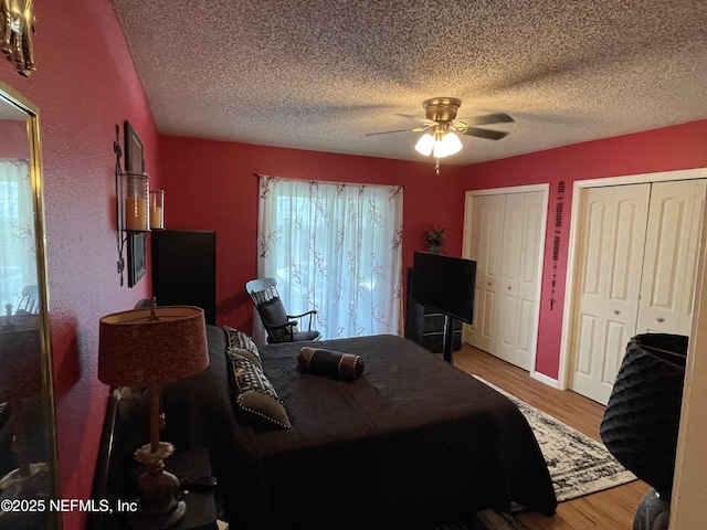 1855 N Alberta Ct, Middleburg, FL 32068 - bedroom with wood finished floors, multiple closets, a textured ceiling, and a ceiling fan