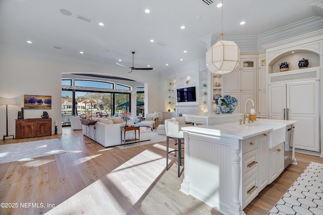 112 Harbourmaster Ct, Ponte Vedra Beach, FL 32082 - kitchen with open floor plan, ornamental molding, a center island with sink, built in features, and open shelves