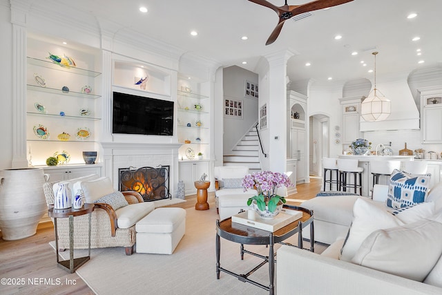 112 Harbourmaster Ct, Ponte Vedra Beach, FL 32082 - living area with ornamental molding, a ceiling fan, stairs, light wood-type flooring, and a brick fireplace