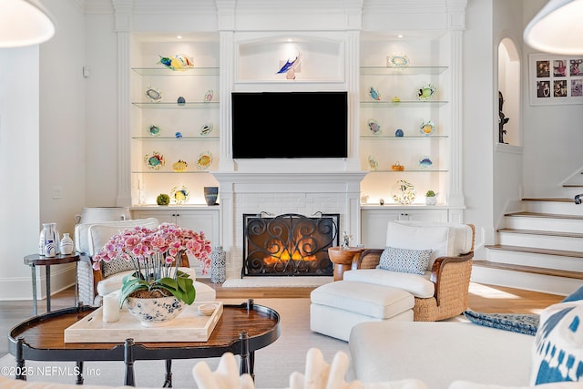 112 Harbourmaster Ct, Ponte Vedra Beach, FL 32082 - living room with built in shelves, wood finished floors, arched walkways, and stairway