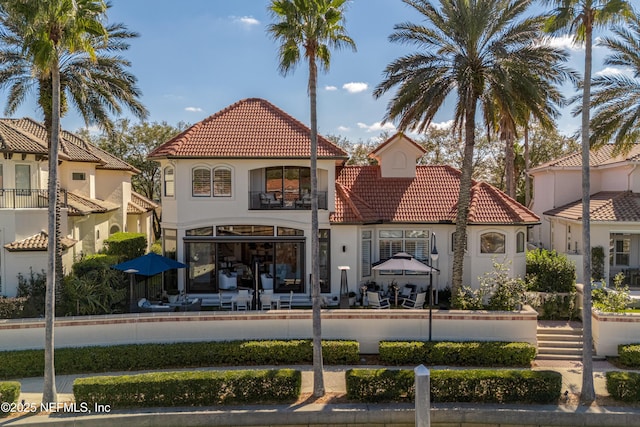 112 Harbourmaster Ct, Ponte Vedra Beach, FL 32082 - rear view of house with a tile roof, a fenced front yard, a balcony, and stucco siding