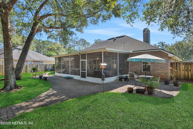 1685 Pinecrest Dr, Fleming Island, FL 32003 - back of property with a sunroom, a patio area, a fenced backyard, brick siding, and a chimney