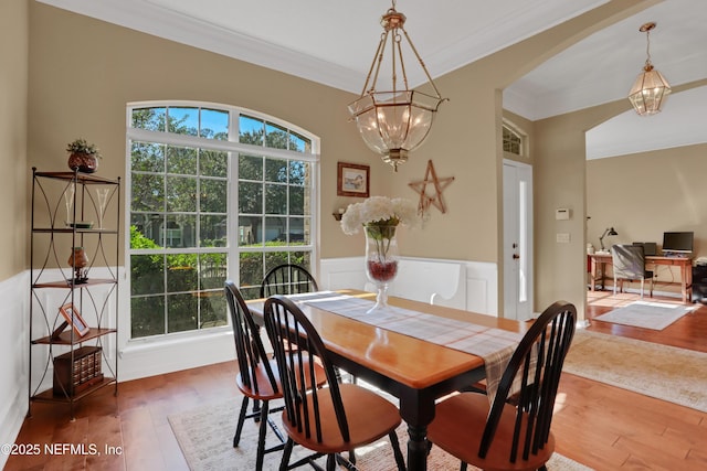 1685 Pinecrest Dr, Fleming Island, FL 32003 - dining space with a chandelier, crown molding, wood finished floors, and wainscoting