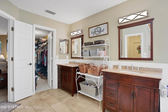 1685 Pinecrest Dr, Fleming Island, FL 32003 - ensuite bathroom with vanity, a wainscoted wall, and a spacious closet