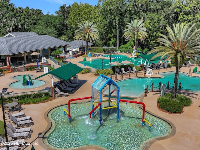 1685 Pinecrest Dr, Fleming Island, FL 32003 - community pool with a water play area, a water slide, a patio area, and view of wooded area