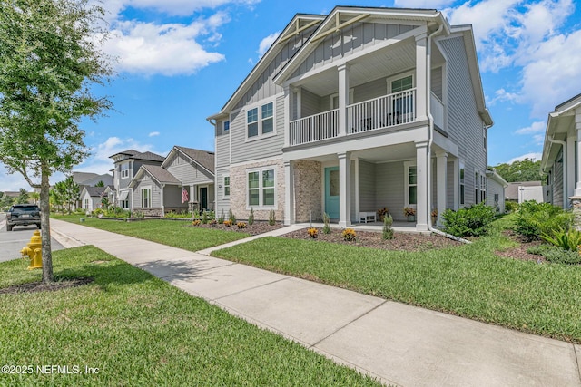 902 Orange Branch Trl, Saint Johns, FL 32259 - view of front facade featuring board and batten siding, a balcony, a porch, a front yard, and a residential view
