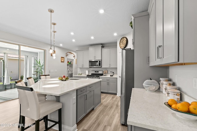 902 Orange Branch Trl, Saint Johns, FL 32259 - kitchen with stainless steel appliances, gray cabinets, light wood finished floors, recessed lighting, and a breakfast bar