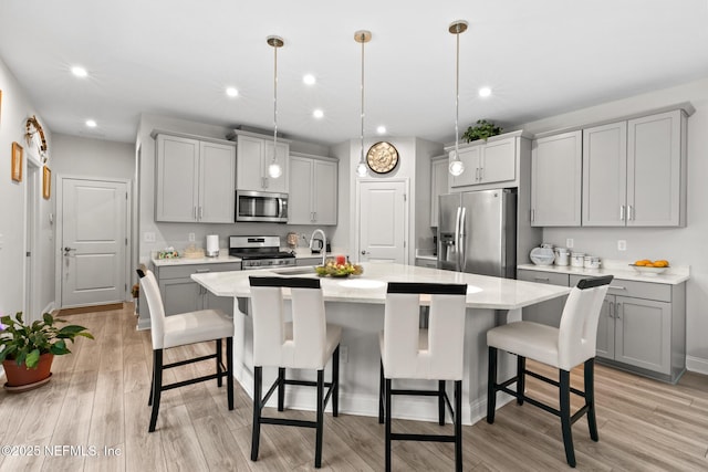 902 Orange Branch Trl, Saint Johns, FL 32259 - kitchen with stainless steel appliances, gray cabinets, a center island with sink, light wood-type flooring, and recessed lighting