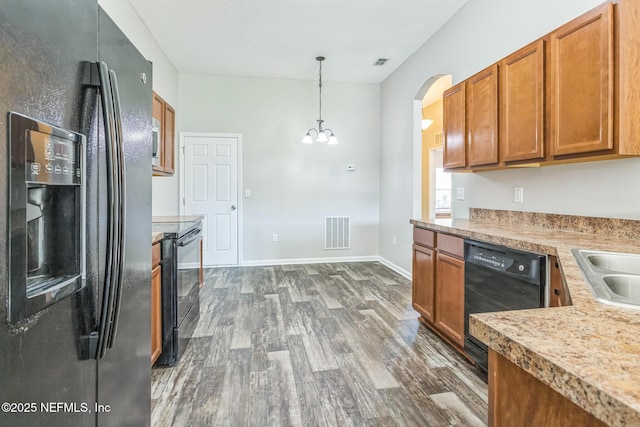 95886 Graylon Dr, Yulee, FL 32097 - kitchen featuring black appliances, dark wood-style flooring, arched walkways, brown cabinetry, and light countertops