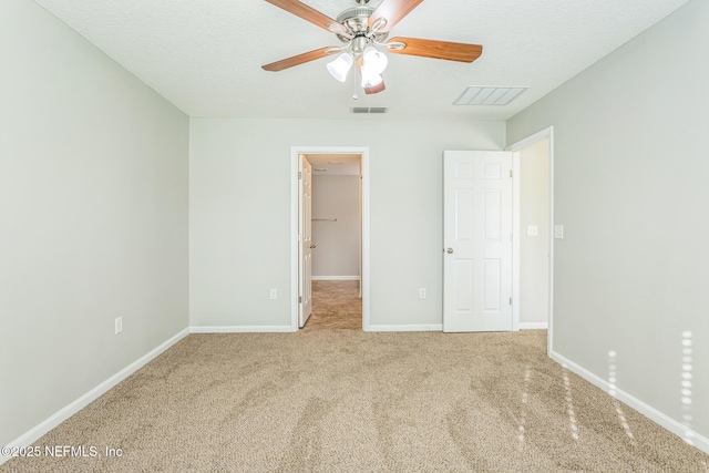 95886 Graylon Dr, Yulee, FL 32097 - unfurnished bedroom featuring a spacious closet, carpet floors, a ceiling fan, and a textured ceiling