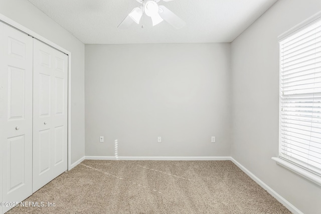 95886 Graylon Dr, Yulee, FL 32097 - unfurnished bedroom with carpet, multiple windows, a closet, and a ceiling fan