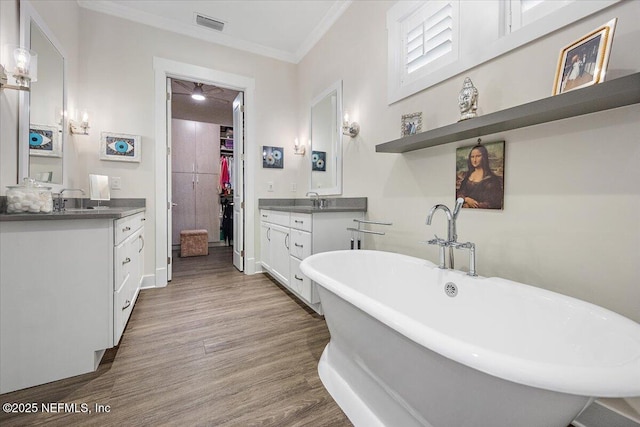 1639 Maritime Oak Dr, Atlantic Beach, FL 32233 - bathroom featuring two vanities, ornamental molding, wood finished floors, a freestanding bath, and a spacious closet