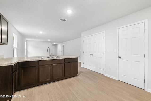 8077 Devoe St, Jacksonville, FL 32220 - kitchen featuring light wood finished floors, dark brown cabinets, a peninsula, light countertops, and recessed lighting
