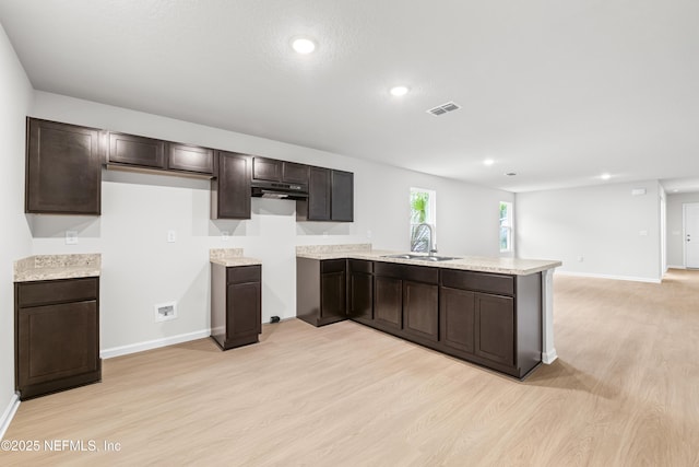 8077 Devoe St, Jacksonville, FL 32220 - kitchen with light wood-style floors, dark brown cabinetry, a peninsula, light countertops, and recessed lighting
