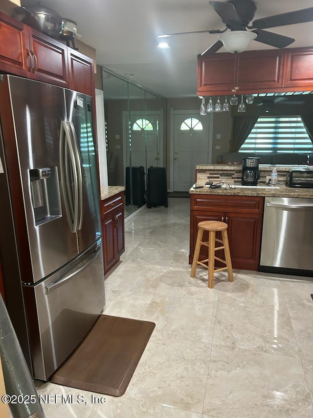 2788 SW 46th Ct, Fort Lauderdale, FL 33312 - kitchen featuring appliances with stainless steel finishes, a ceiling fan, reddish brown cabinets, and plenty of natural light