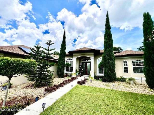 16325 Magnolia Bluff Dr, Montverde, FL 34756 - view of front of home featuring stucco siding, a front lawn, and french doors