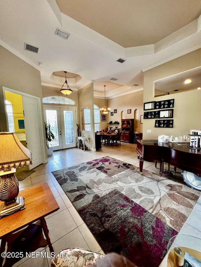 16325 Magnolia Bluff Dr, Montverde, FL 34756 - living room featuring tile patterned flooring, crown molding, french doors, a tray ceiling, and a chandelier