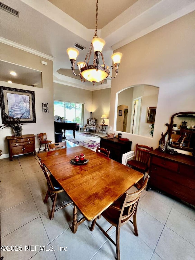 16325 Magnolia Bluff Dr, Montverde, FL 34756 - dining room featuring a tray ceiling, tile patterned floors, ornamental molding, arched walkways, and a chandelier