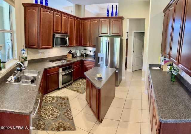 16325 Magnolia Bluff Dr, Montverde, FL 34756 - kitchen with dark countertops, appliances with stainless steel finishes, a center island, and light tile patterned floors