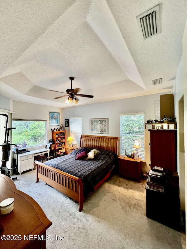 16325 Magnolia Bluff Dr, Montverde, FL 34756 - carpeted bedroom with a textured ceiling, a raised ceiling, multiple windows, and a ceiling fan