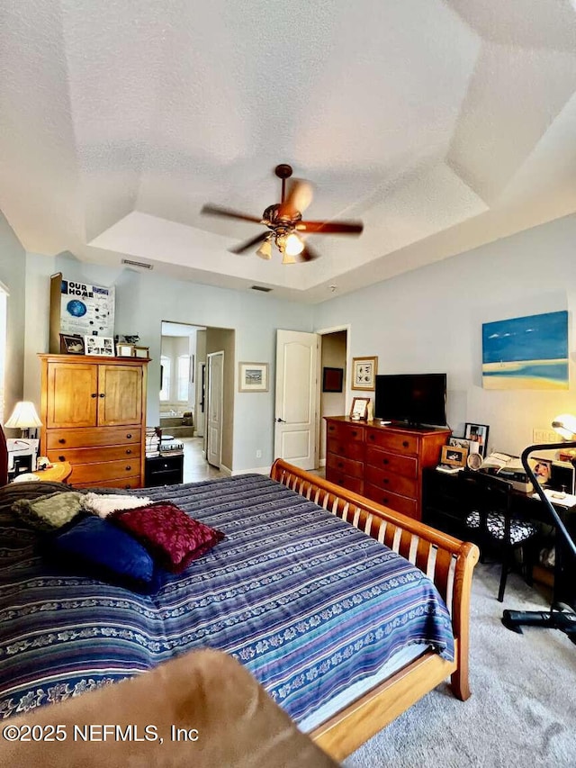 16325 Magnolia Bluff Dr, Montverde, FL 34756 - bedroom with carpet, a textured ceiling, a tray ceiling, and ceiling fan