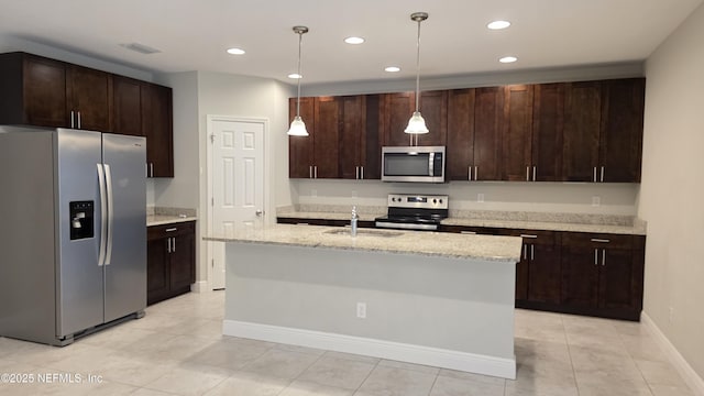 228 Clayton St, Brandon, FL 33511 - kitchen featuring stainless steel appliances, dark brown cabinets, recessed lighting, light tile patterned flooring, and a kitchen island with sink