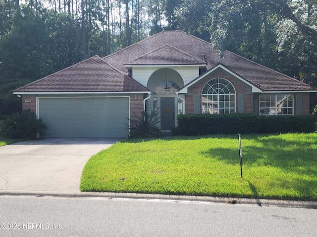 5842 Piper Glen Blvd, Jacksonville, FL 32222 - view of front of property featuring an attached garage, a front lawn, concrete driveway, and brick siding
