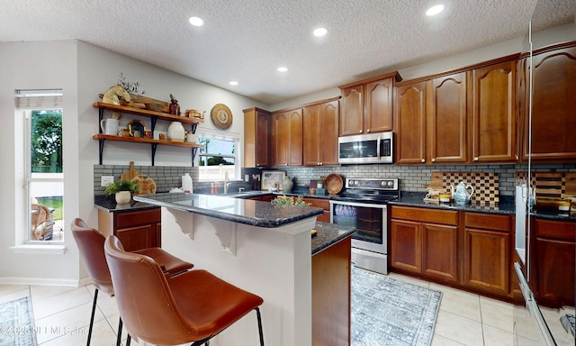 1361 Wekiva Way, Saint Augustine, FL 32092 - kitchen with appliances with stainless steel finishes, a center island, light tile patterned floors, backsplash, and open shelves