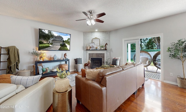 1361 Wekiva Way, Saint Augustine, FL 32092 - living room with a ceiling fan, wood finished floors, a textured ceiling, and a tiled fireplace