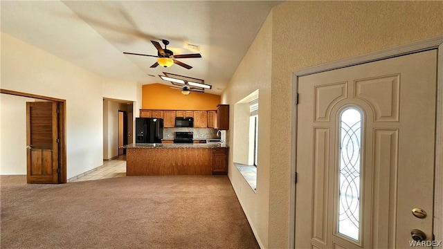 kitchen with lofted ceiling, light colored carpet, a peninsula, brown cabinets, and black appliances