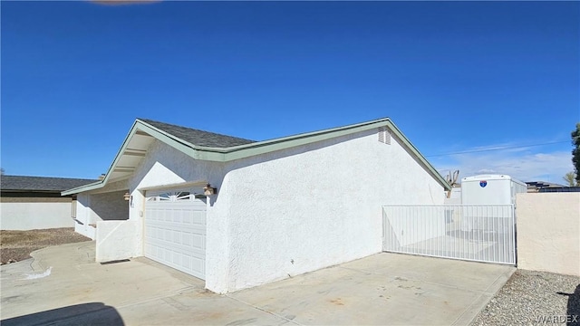 view of property exterior featuring a garage, fence, and stucco siding