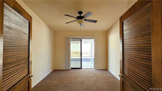 spare room with a textured ceiling, baseboards, a ceiling fan, and light colored carpet