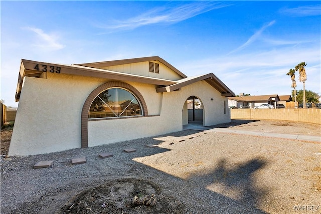 view of front facade featuring fence and stucco siding