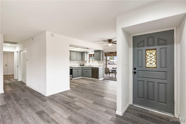 foyer entrance featuring dark wood-type flooring, baseboards, and a ceiling fan